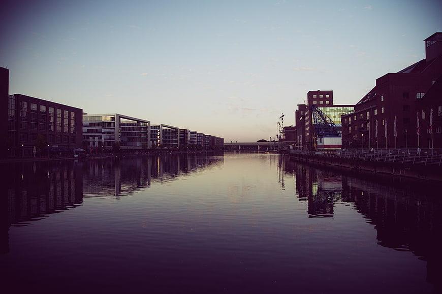 Serene Urban Canal Reflection at Dusk with Modern Architecture