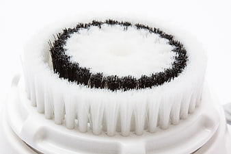 Close-up of white and black sonic facial cleansing brush head