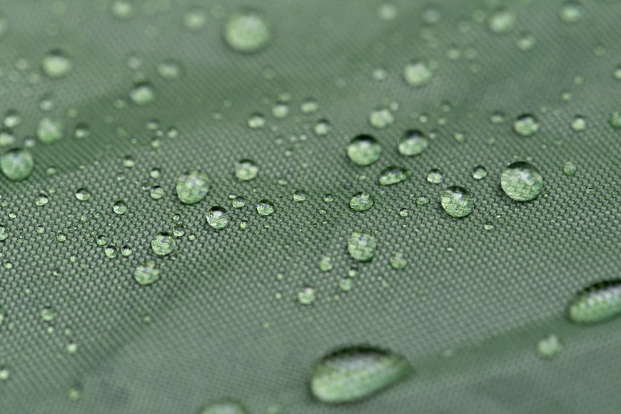 Macro water droplets on green waterproof tent fabric