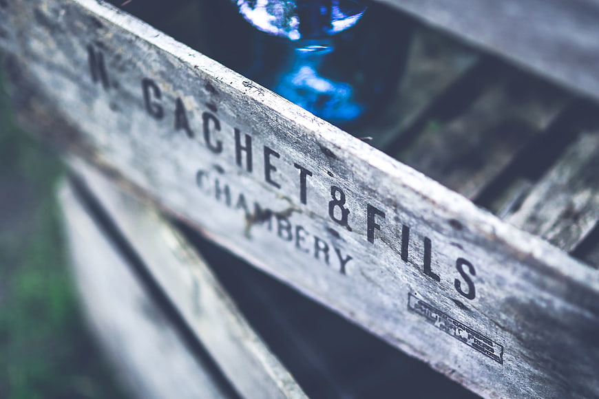 Vintage wooden crate with stenciled text and blue glass bottle