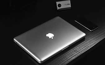 Silver Apple Laptop and Smartphone on Dark Wooden Desk