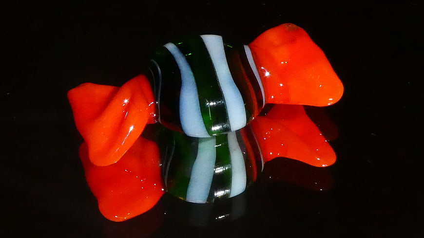 Colorful glass candy sculpture on black reflective surface