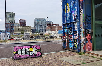 Urban street art graffiti on blue container and concrete block