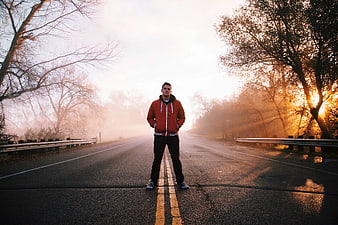 Man Standing on Foggy Road at Sunrise