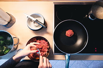 Top view of hands cooking ground beef burger patty in kitchen