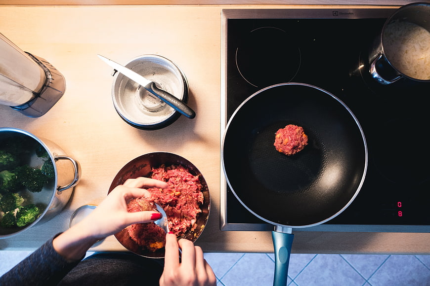 Top view of hands cooking ground beef burger patty in kitchen