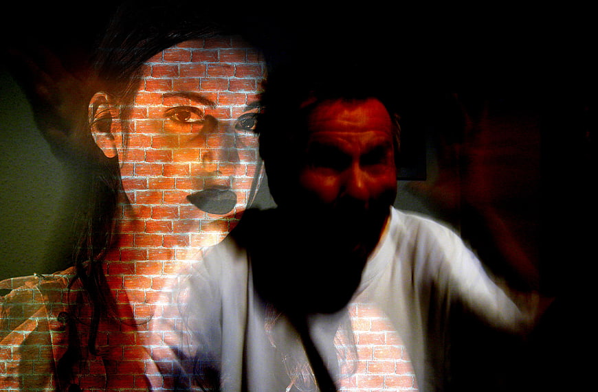 Double exposure portrait of woman and man with brick wall texture