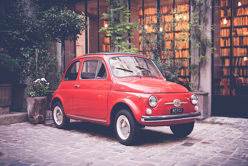 Vintage Red Fiat 500 Parked on Cobblestone Street