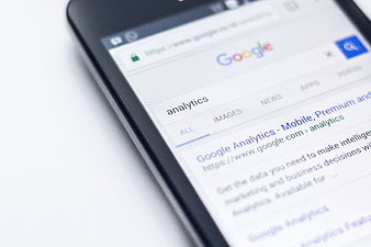 Smartphone displaying Google Analytics search results on a white background