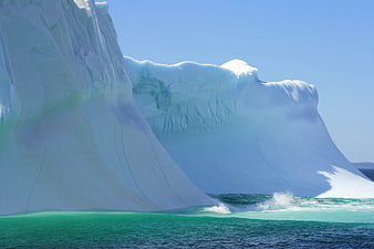 Massive Blue Iceberg Floating in Turquoise Arctic Ocean