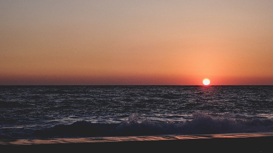 Serene Sunset Over Ocean Waves on Sandy Beach