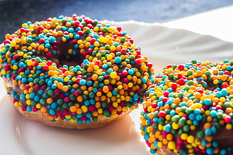 Chocolate Frosted Donuts With Colorful Sprinkles On White Plate