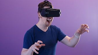 Man Wearing VR Headset Reaching Out Against Purple Background