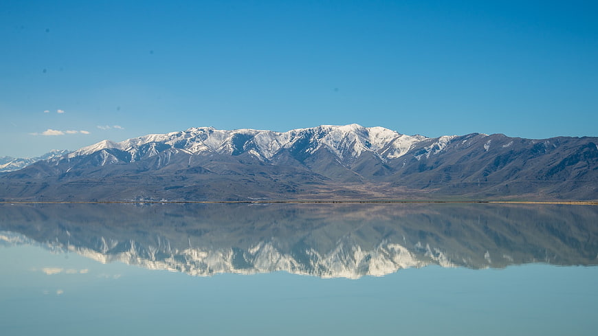 Snow-capped mountains reflected in calm lake water