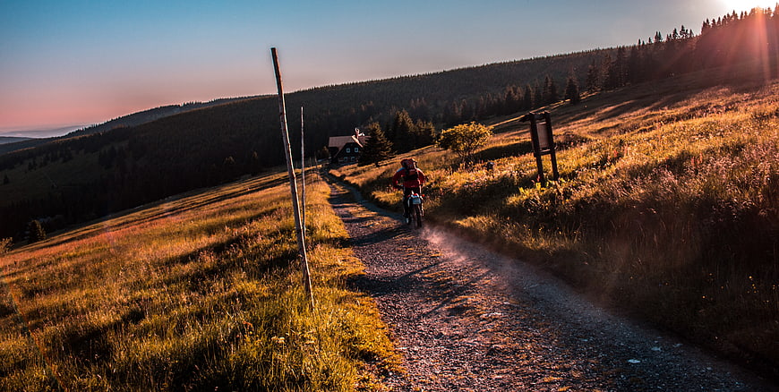 Motorcyclist Riding on Gravel Mountain Road at Sunset