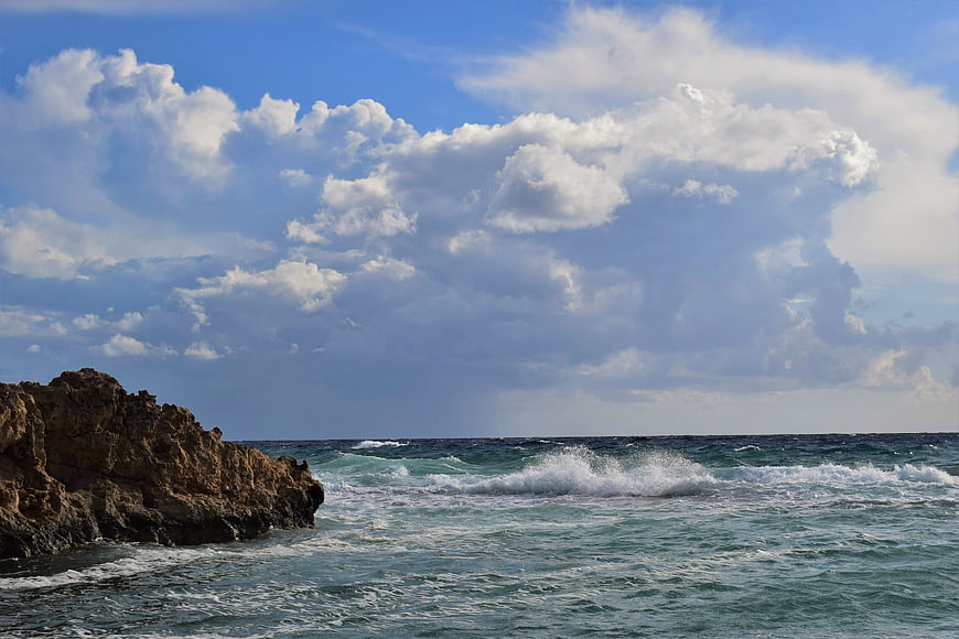 Dramatic Rocky Coastline with Crashing Waves and Cloudy Sky