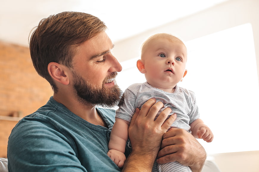 Happy Father Holding Baby Indoors