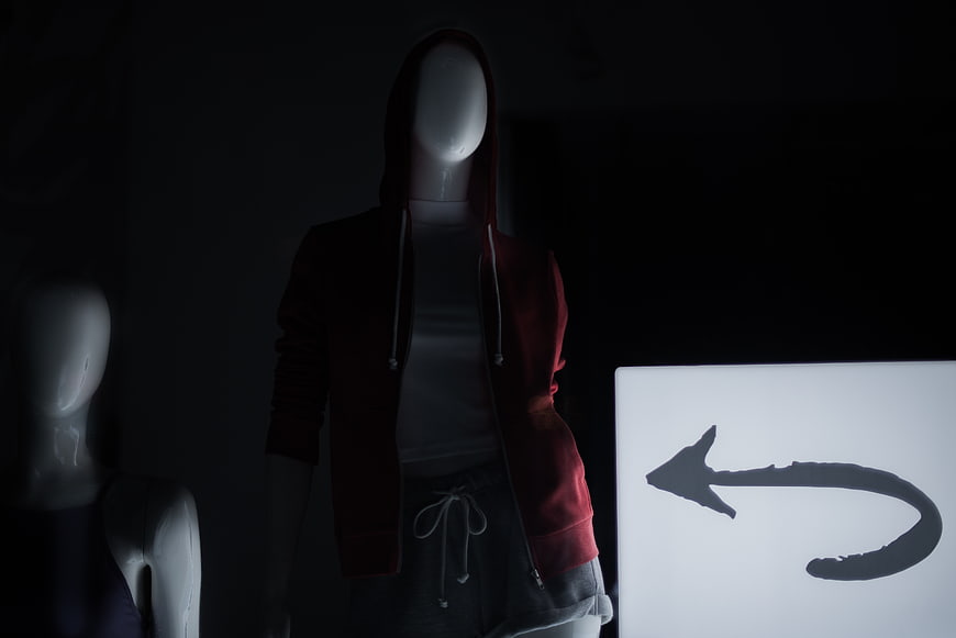 Mannequin in Red Hoodie with Glowing Arrow Sign