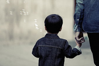 Child holding parent's hand walking with bubbles