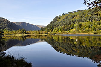 Serene Lake Reflection in Lush Green Mountain Valley