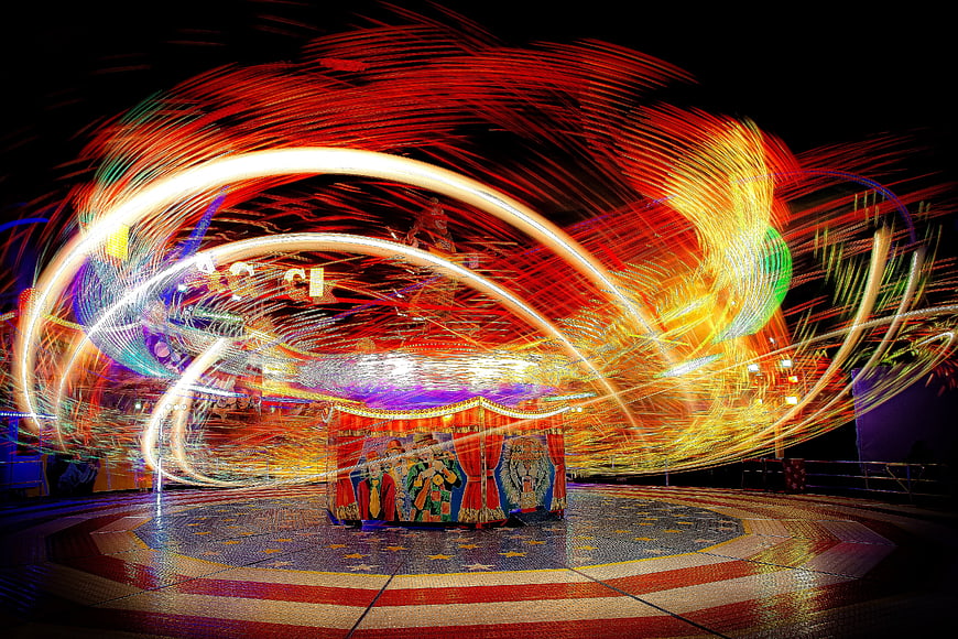 Long exposure light trails on a spinning fairground ride at night