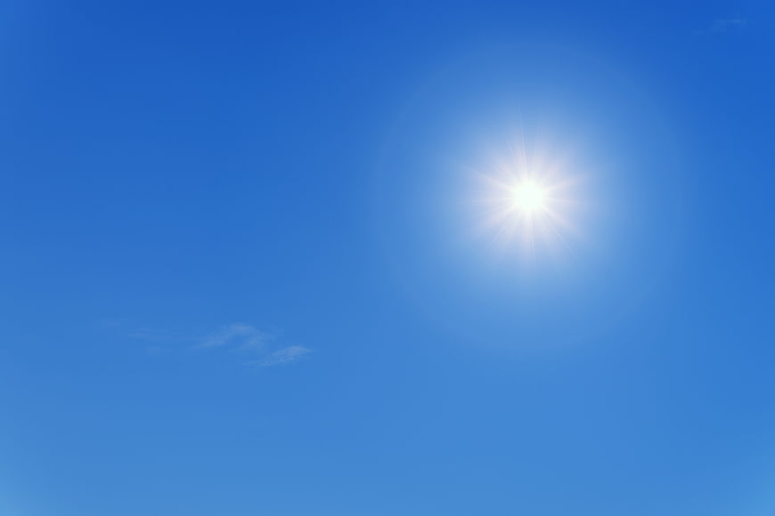 Bright Sun In Clear Blue Sky With Sunburst Rays