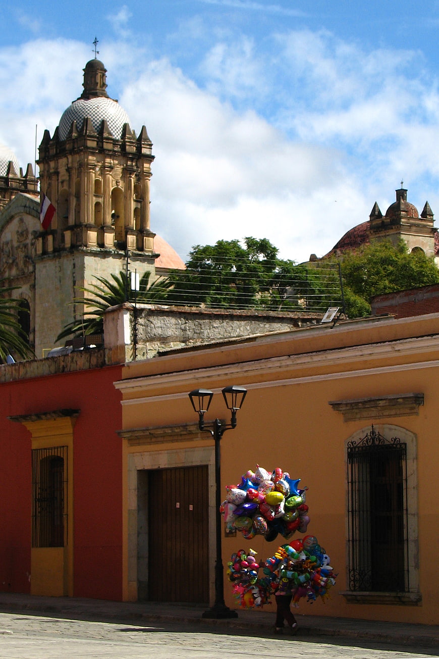 Balloon Seller Walking Past Colonial Architecture in Oaxaca