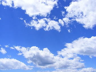 Fluffy white clouds against a vibrant blue sky background