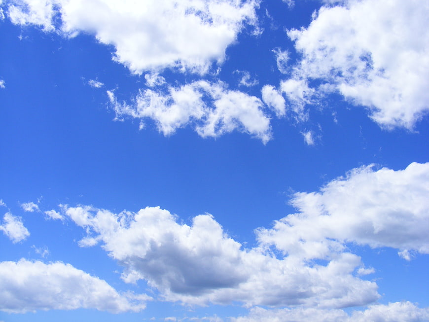 Fluffy white clouds against a vibrant blue sky background
