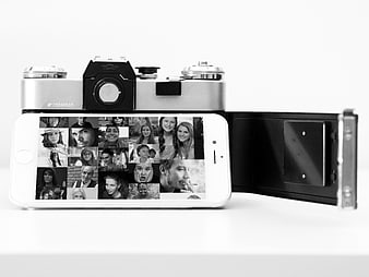 Vintage SLR camera and smartphone displaying photo grid on white background