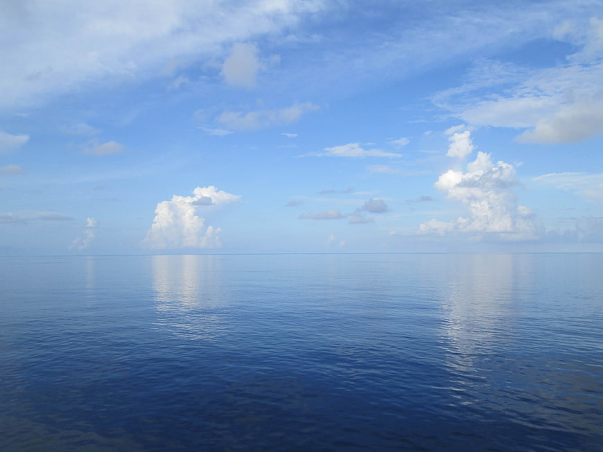 Serene Ocean Horizon with Fluffy White Clouds