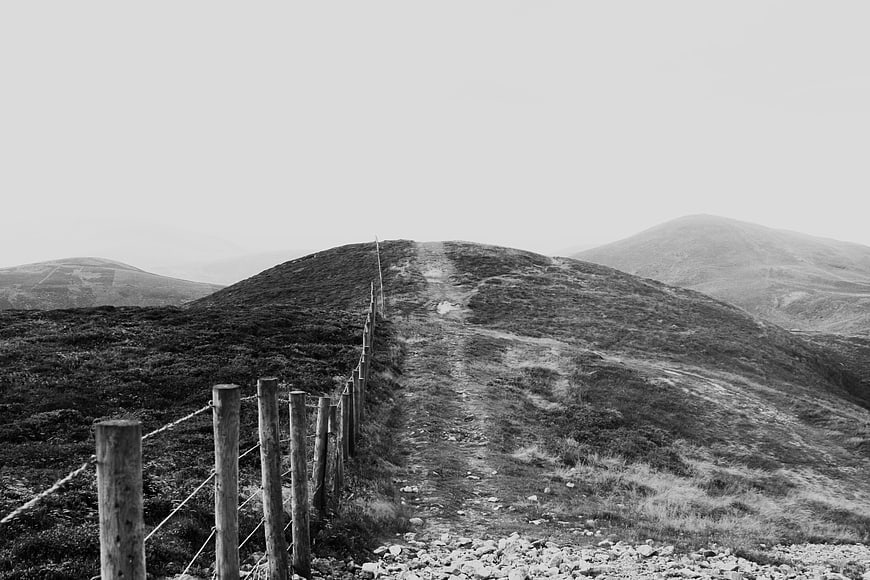 Black and white hiking trail on misty mountain ridge