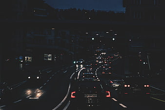 Night traffic on a wet city street under an overpass