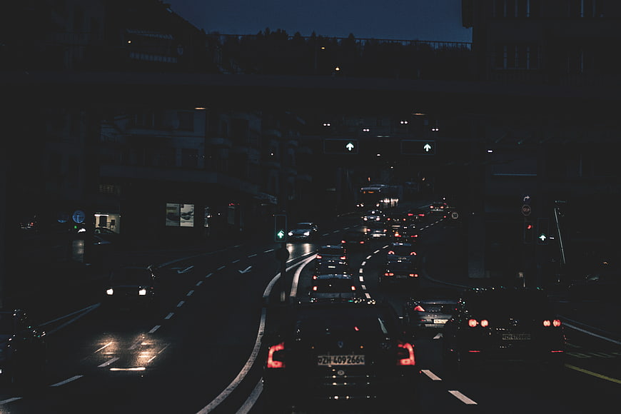 Night traffic on a wet city street under an overpass