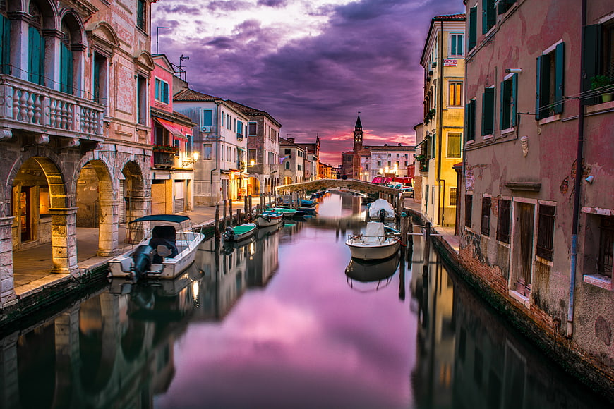 Venetian Canal at Dusk with Vibrant Purple Sky and Boats