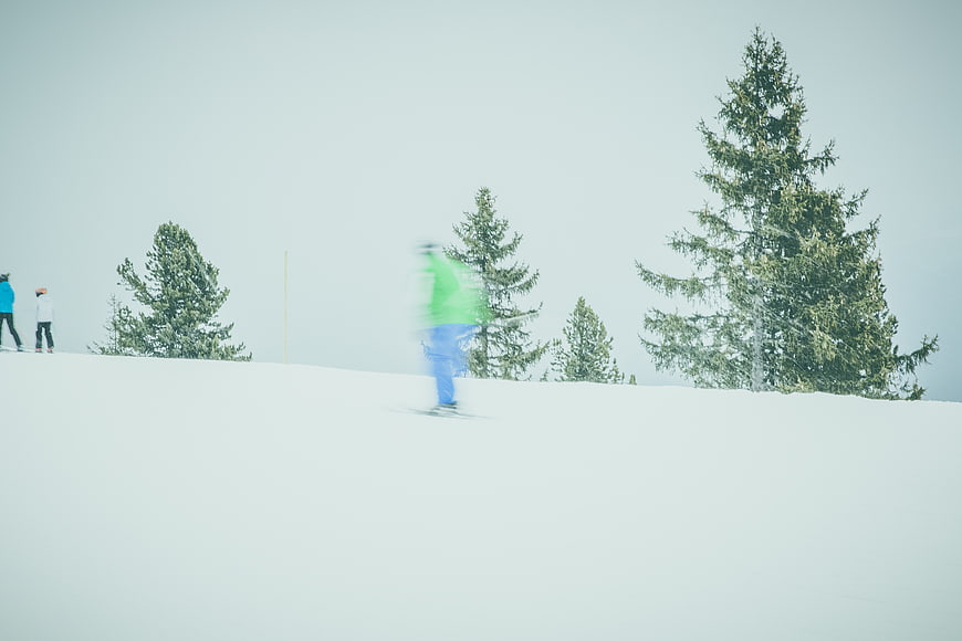 Motion Blur Skier on Snowy Slope with Pine Trees