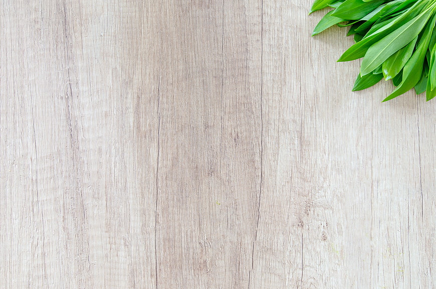 Fresh Green Leaves on Light Wood Background