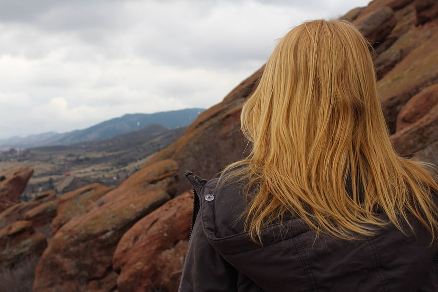 Blonde Woman Looking at Red Rock Mountain Landscape