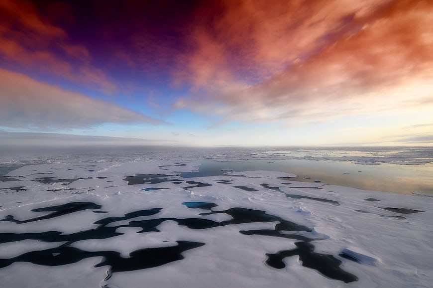 Aerial View of Arctic Sea Ice Under Dramatic Sunset Sky