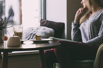 Woman relaxing with coffee and cake in cozy cafe interior