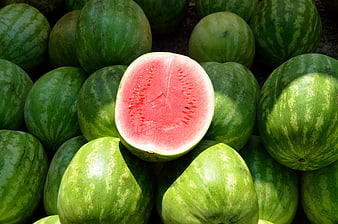 Fresh Cut Watermelon Displayed On A Pile Of Whole Green Watermelons