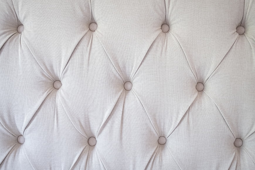 Close-up of white tufted upholstery fabric texture