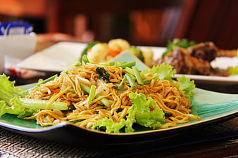 Sizzling Asian Stir-Fried Noodles With Fresh Vegetables On Green Plate