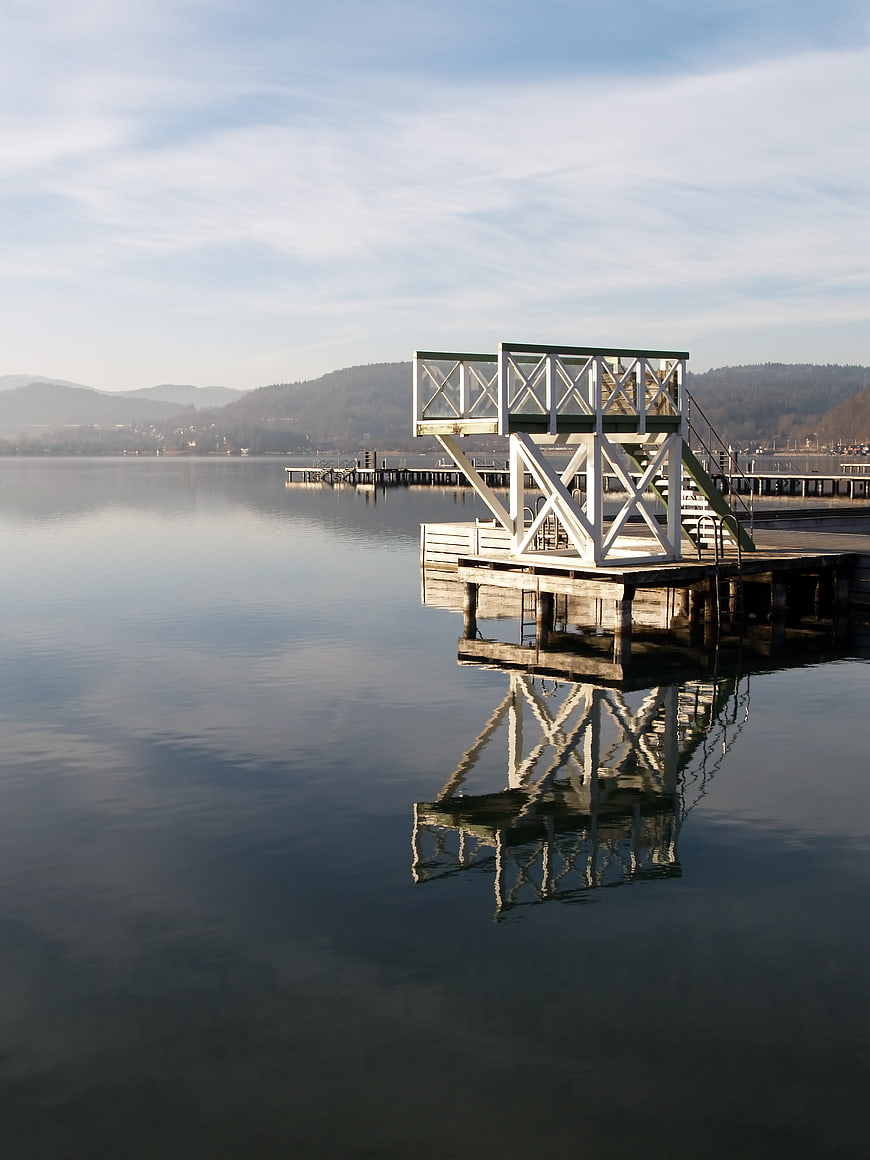 White diving platform on calm lake with reflection