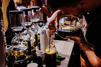 Barista pouring cold brew coffee into a glass bottle