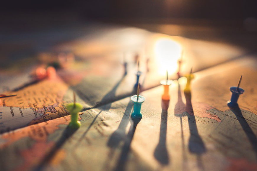 Colorful Push Pins on World Map with Golden Hour Light