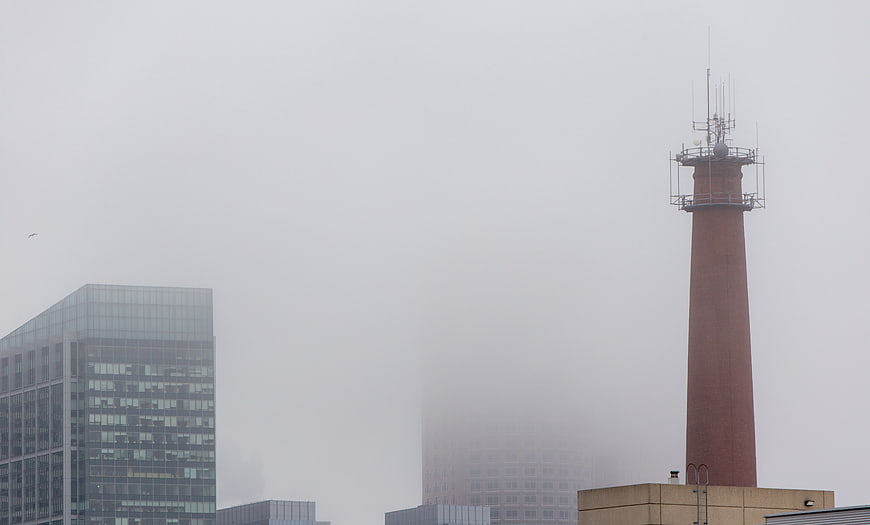 Foggy Urban Cityscape with Brick Tower and Glass Building