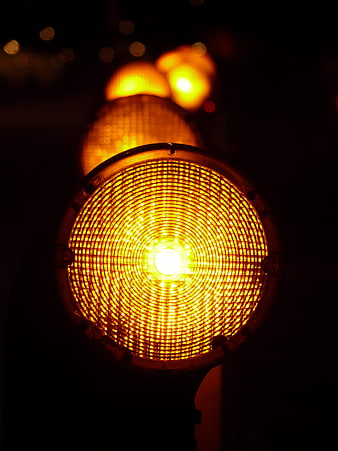 Close-up of glowing yellow warning lights at night
