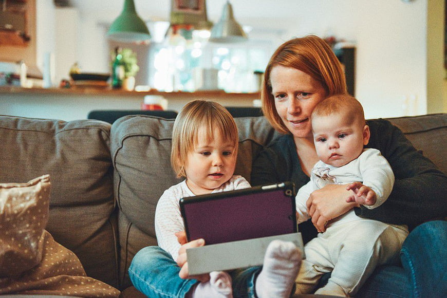 Mother and Two Children Using Tablet on Couch
