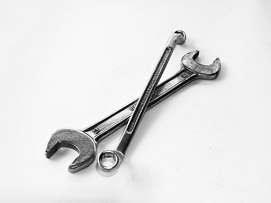 Crossed metal wrenches on white background